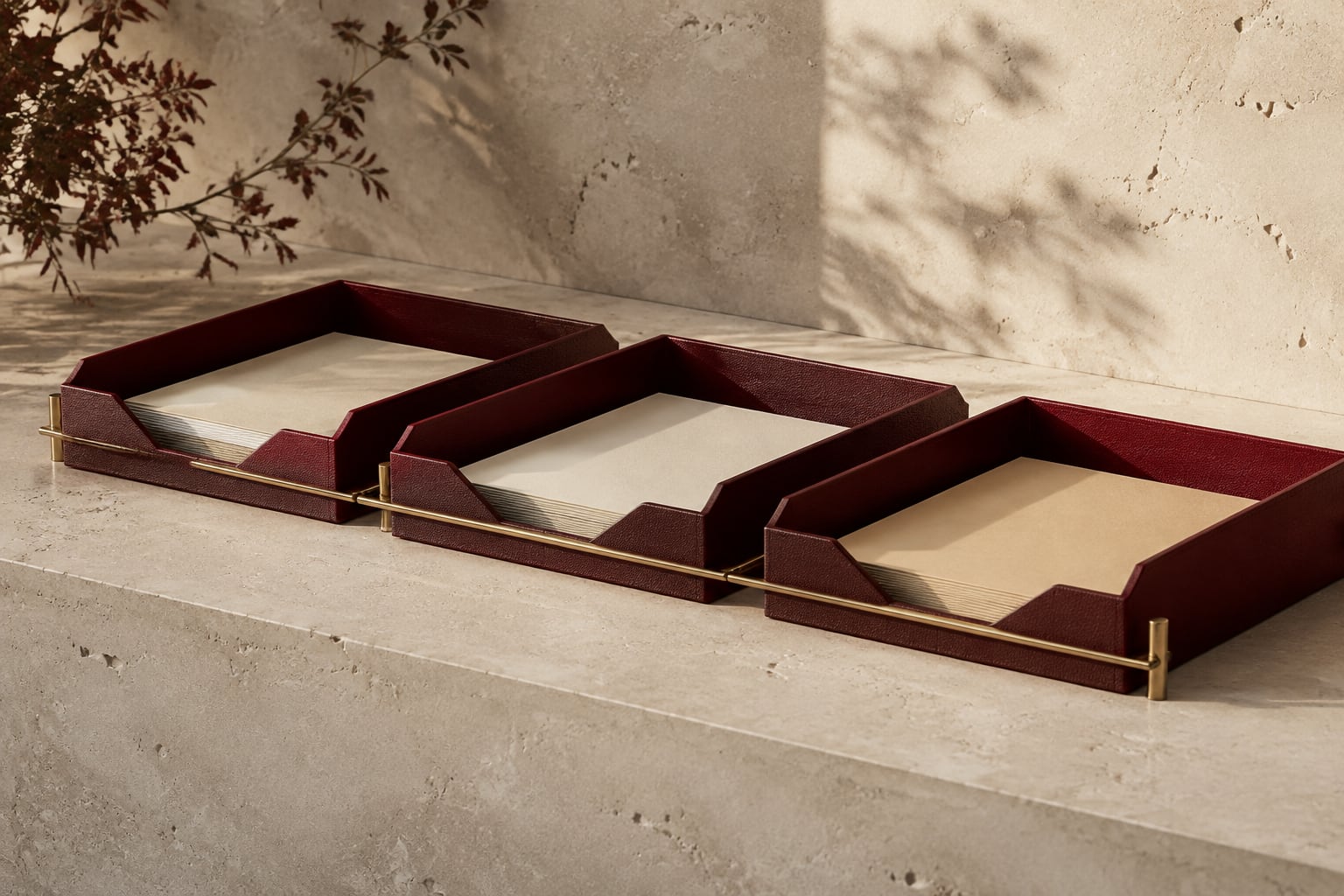 A sequence of burgundy document trays connected across a limestone workbench.